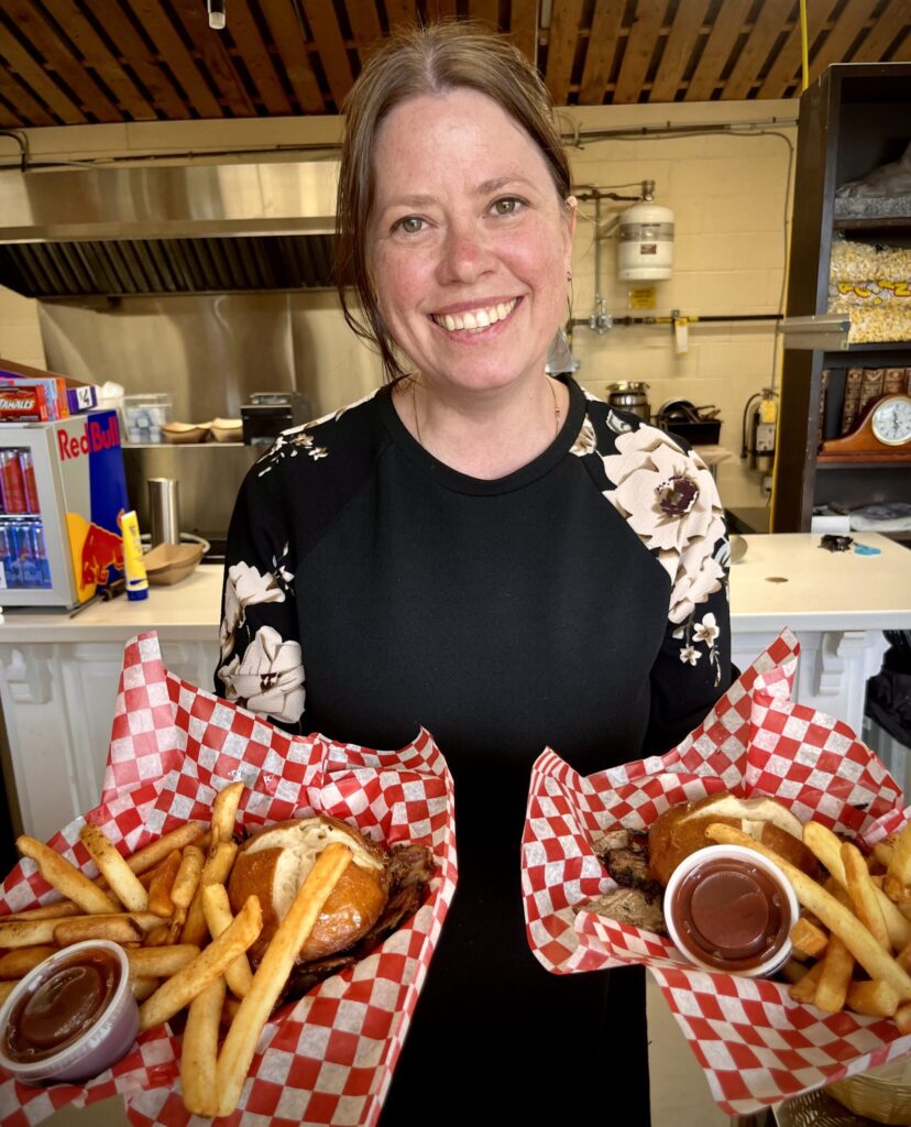 Jacqui presenting two burger platters at the Morse et Marteaux BBQ Canteen at Parlee Beach